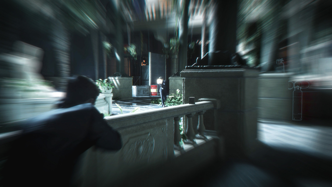 Person in suit aiming a gun from behind a balustrade in a large bright interior with columns and plants at another person in the distance