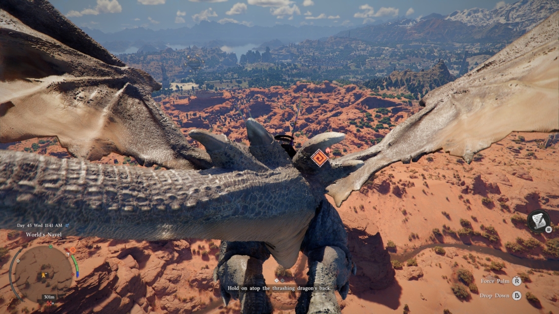 Dragon's scaly back and wings over a rocky desert landscape with mountains in the background