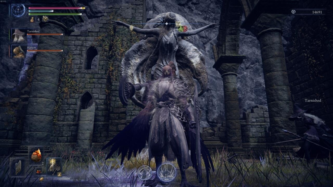 Spielercharakter in dunkler Rüstung mit Flügeln, der einer großen gehörnten Statue in einer Steinruine in Elden Ring Nightreign gegenübersteht.