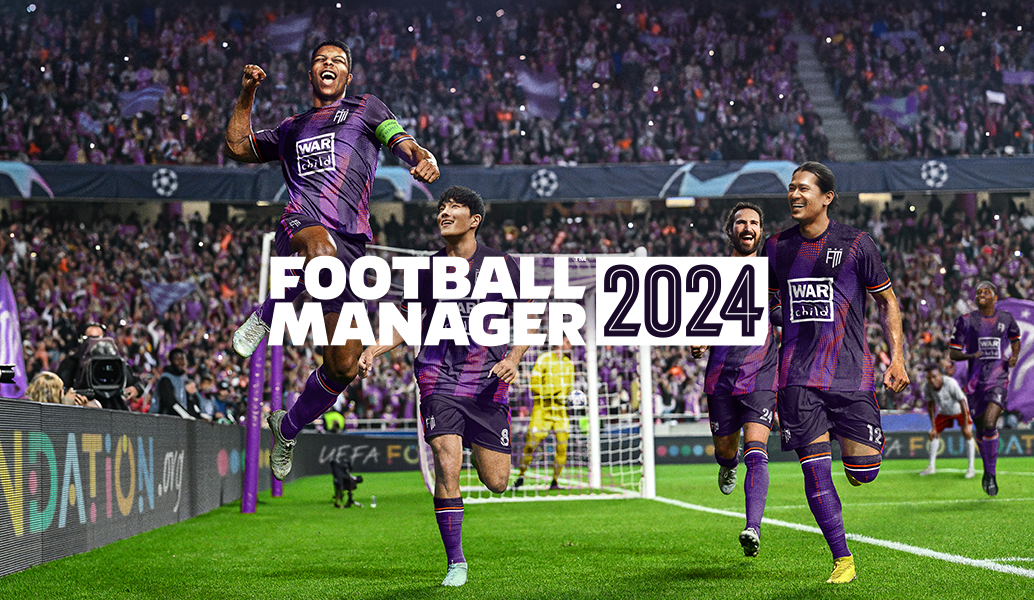 Four football players in purple kits celebrating on a pitch in front of a goal and a crowded stand