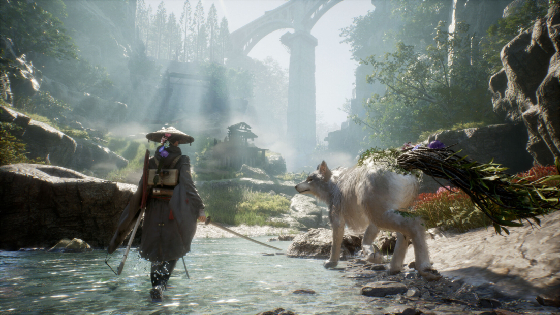 Person wearing a wide-brimmed hat and carrying a sword walks through a shallow stream accompanied by a large wolf carrying a bundle of branches on its back with a stone bridge and forest in the background