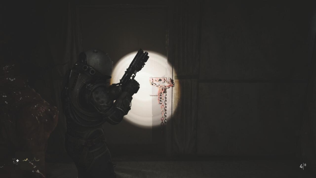 A character in a dark, armored suit holds a weapon, illuminated by a flashlight, aiming at a door with chains and a lock in 'Cronos: The New Dawn'.