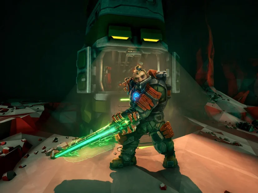 A muscular man in futuristic armor holds a glowing green rifle in front of a large stone robotic head with yellow eyes.