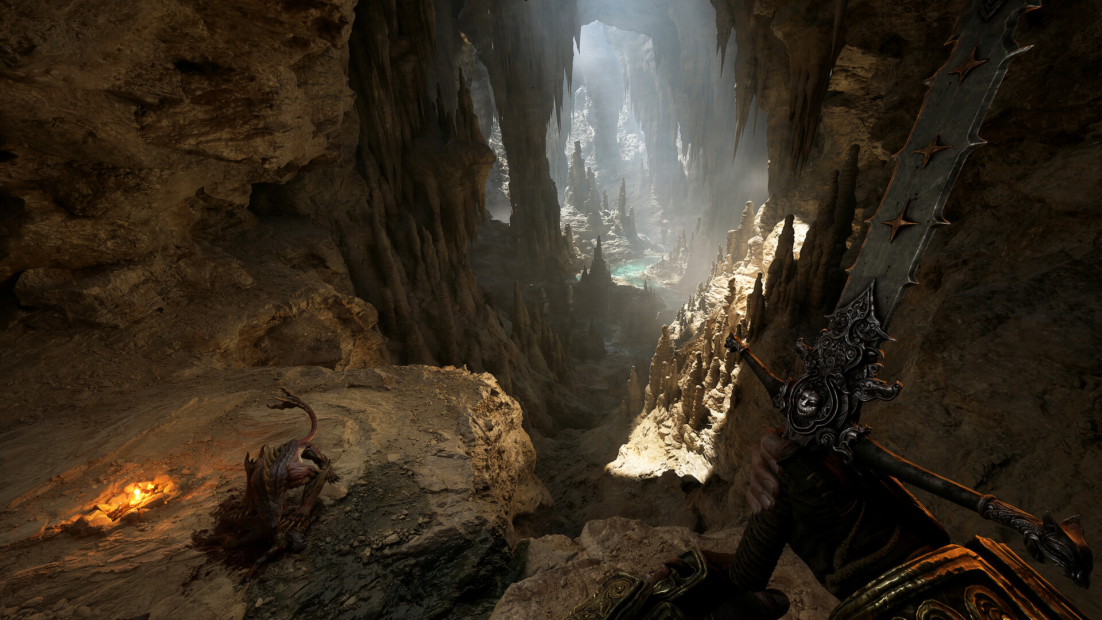 Fatekeeper tips: View from a dark cave into a rocky gorge with beams of light and a large ornate weapon in the foreground