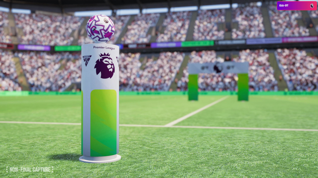 Ein Fußball mit lila Muster liegt auf einem weißen Podest mit dem Premier-League-Logo auf einem Fußballfeld, im Hintergrund Zuschauertribünen.