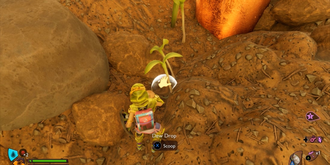 Figur in gelbem Anzug mit Rucksack, die in der Spielumgebung von Grounded 2 einen leuchtenden Tautropfen von einer kleinen Pflanze in einer felsigen Umgebung aufhebt.