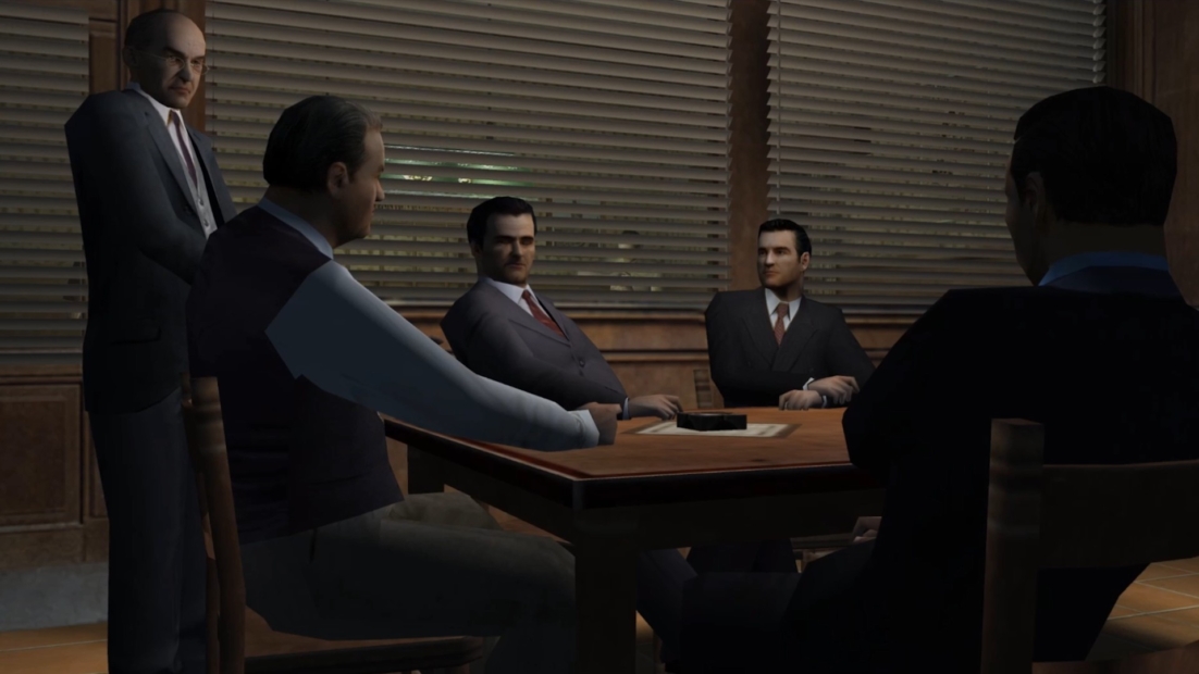 Four men in suits sitting and standing around a wooden table in a dimly lit room with closed blinds, from the game Mafia (2002)