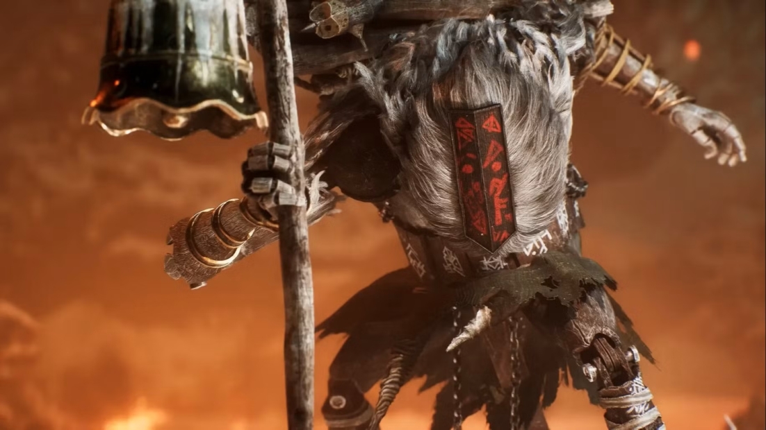 Monoco Build: A humanoid creature with gray fur holding a staff and a bell. It has a decorated chest plate with red symbols and wears multiple bracelets.
