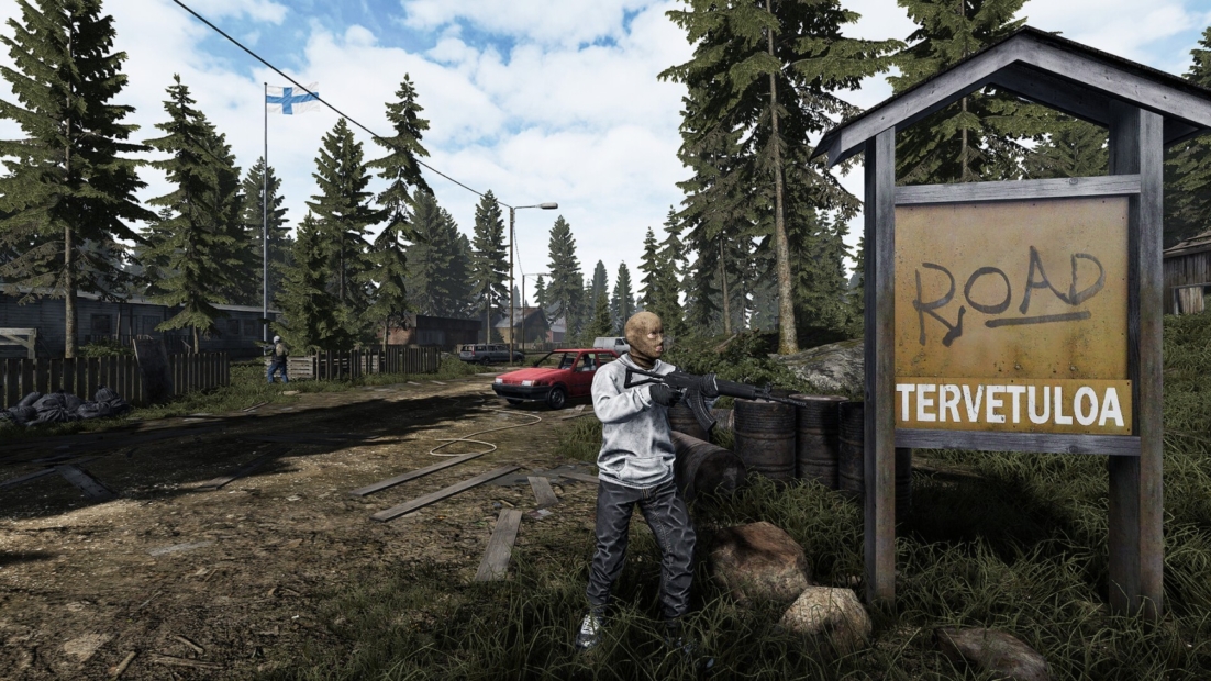 Road to Vostok Guide: Man holding a rifle stands next to a sign reading 'ROAD TERVETULOA' on a forest road with houses and a car in the background