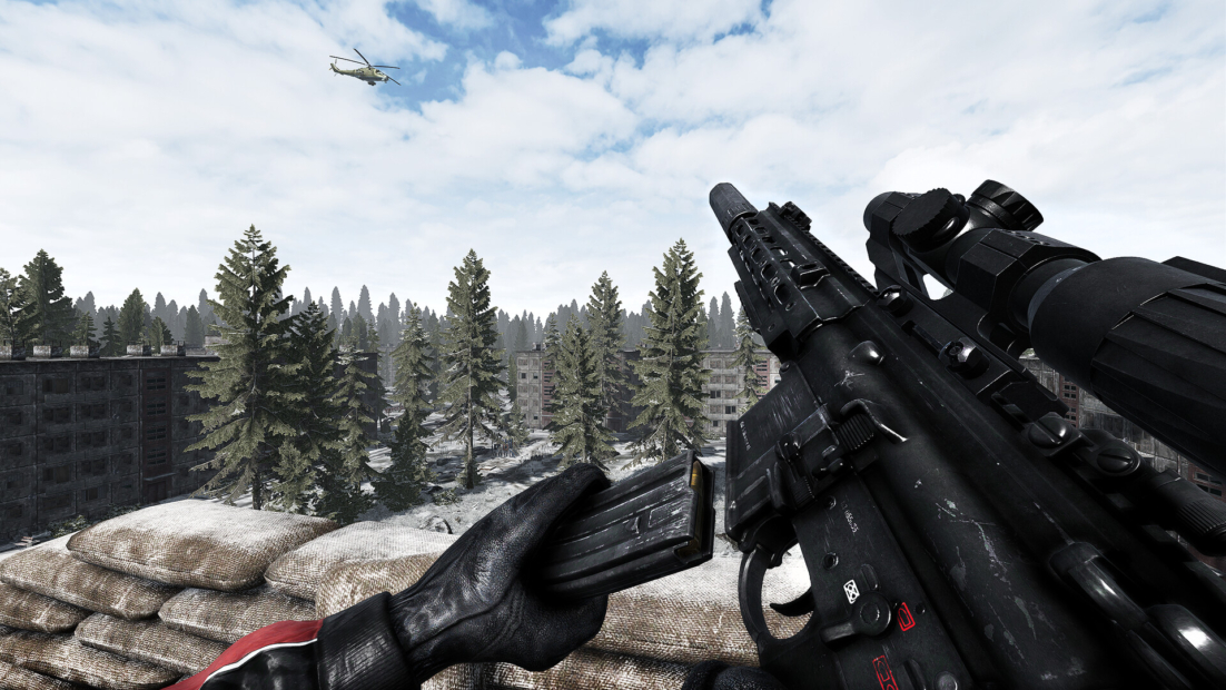 View over a forested landscape with a black rifle in the foreground and a helicopter in the sky