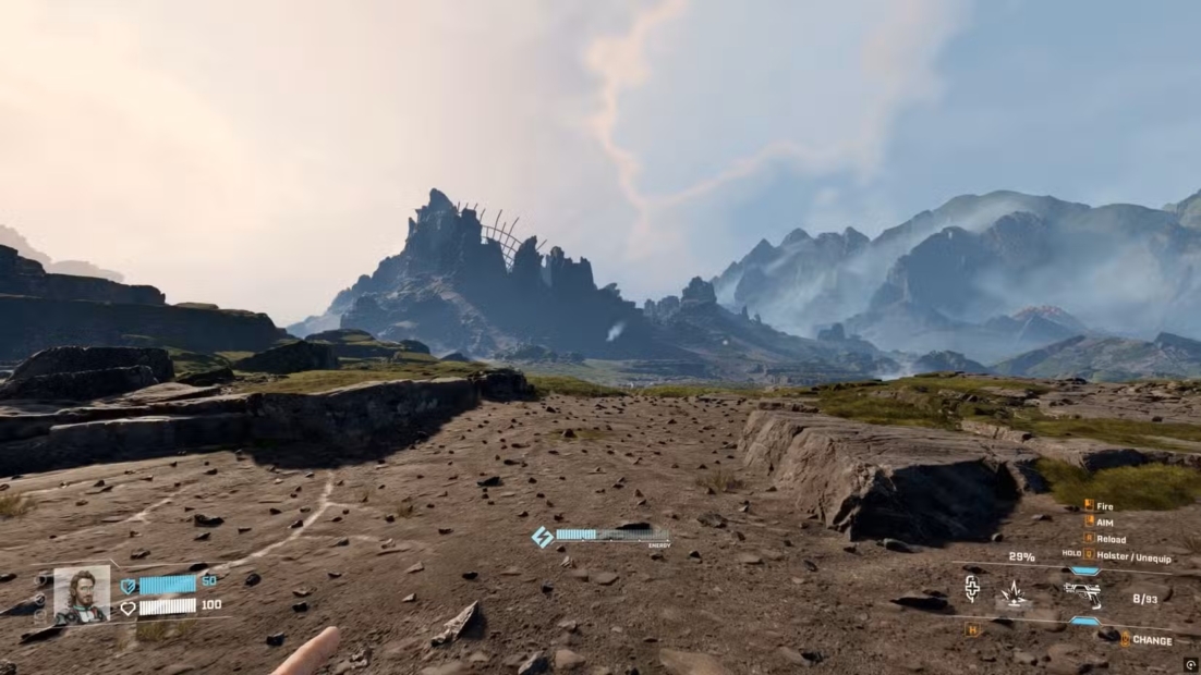 Wide rocky landscape with rugged mountains in the background and a flat, stony plain in the foreground.