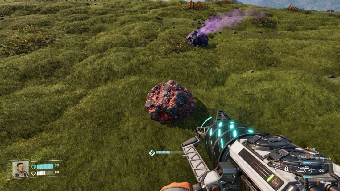 StarRupture Ore: First-person view of a futuristic weapon aimed at two large, irregularly shaped red and black rocks on a grassy hillside.