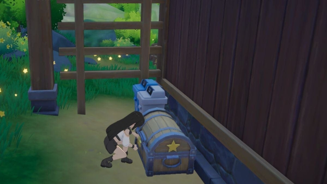 Character crouching to open a chest with a star on it next to a wooden wall and a wooden frame outdoors