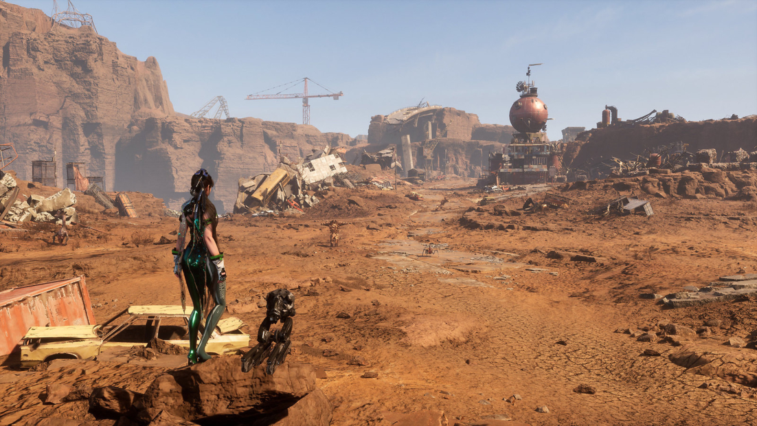A character in futuristic armor and a robot stand on a rocky outcrop overlooking a vast, barren desert landscape with scattered debris, wreckage, and industrial structures under a clear sky in the game Stellar Blade.