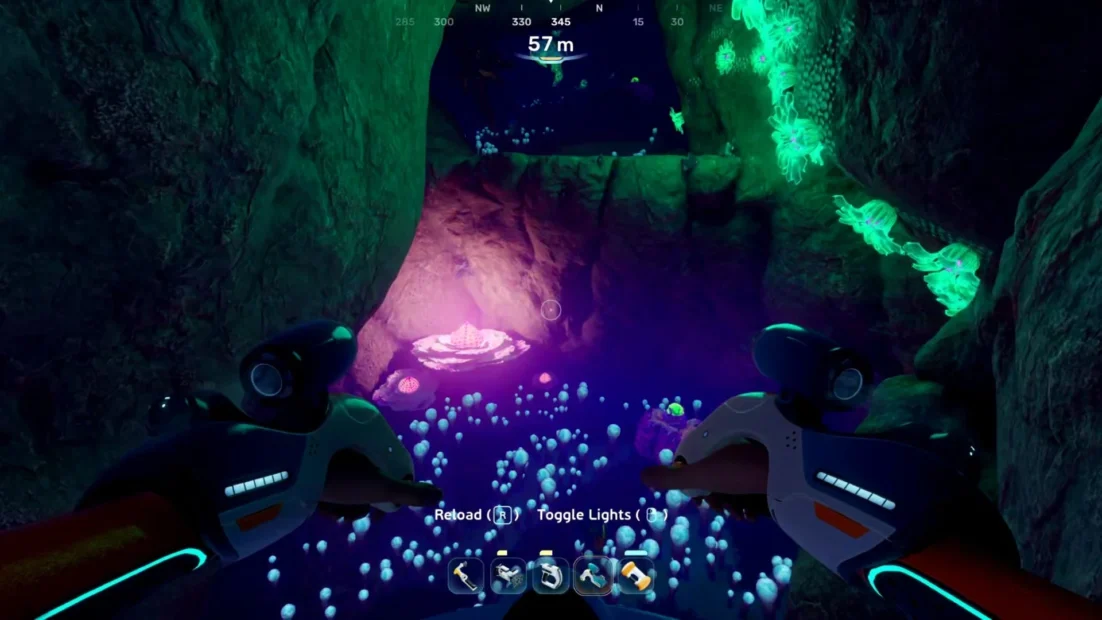 Unterwasserhöhle mit leuchtenden Pflanzen und zwei Händen in Taucherhandschuhen im Vordergrund