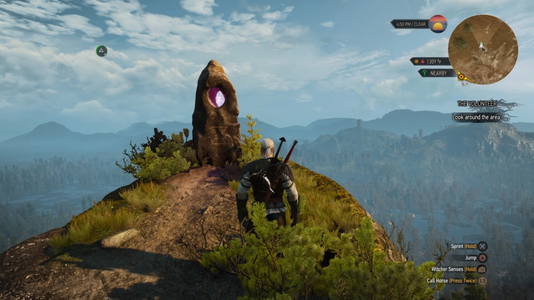 Game character with two swords on back stands before a large stone monolith with purple glow in an opening, surrounded by mountains.