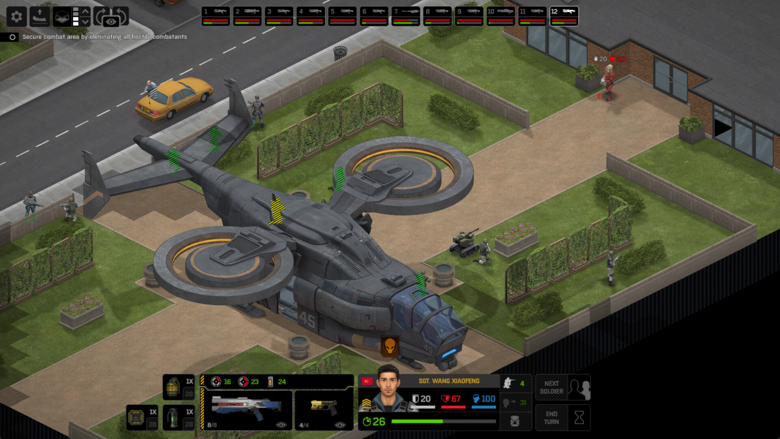 Drone helicopter on a paved courtyard next to a building with several soldiers in camouflage uniforms and hedges